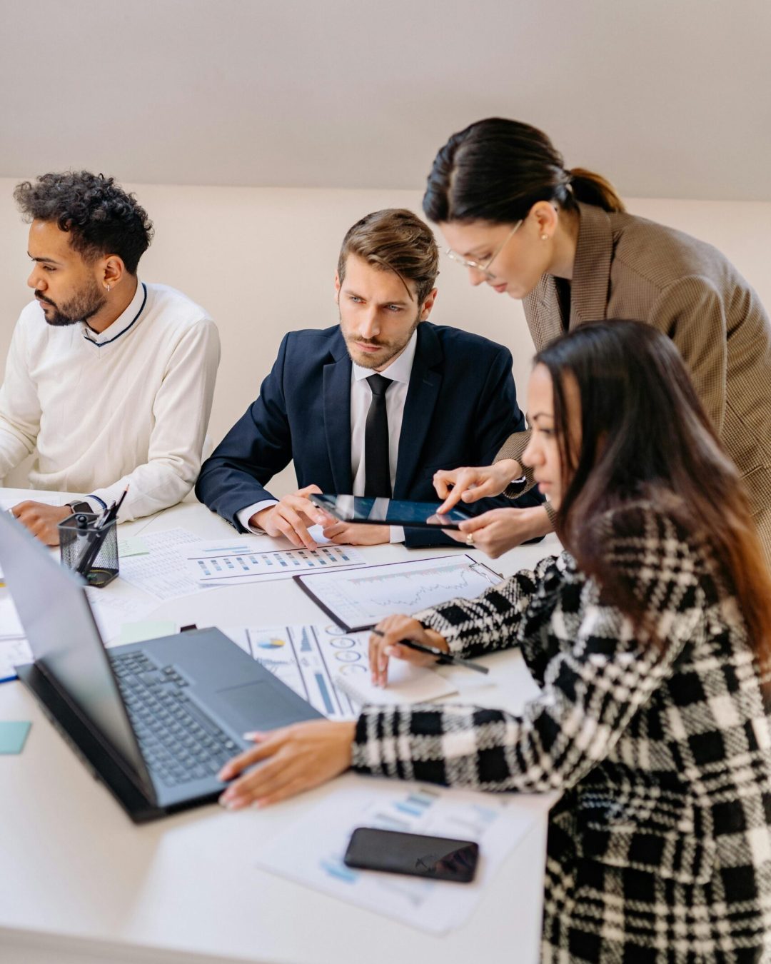 Professionals engaged in a meeting discussing plans in a modern office setting.